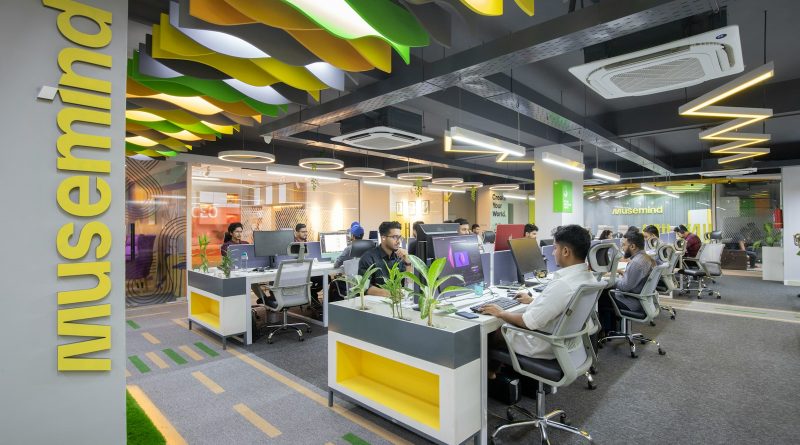 a group of people sitting at desks in an office